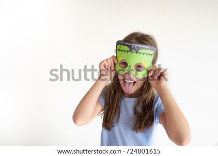 The girl plays the fool in a mask of the monster Royalty-Free Stock Photo #724801615