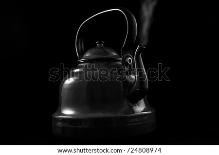 Black and white teapot isolated with steam.