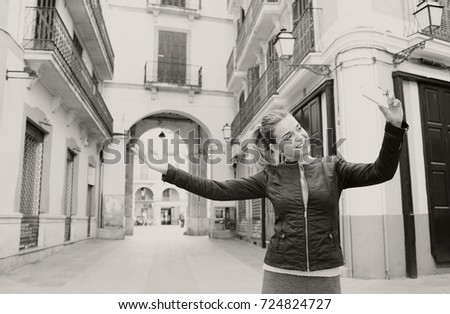 Black and white portrait of young tourist woman visiting destination city on holiday, pointing smart phone camera, taking selfies pictures, smiling networking. Travel technology recreation lifestyle.