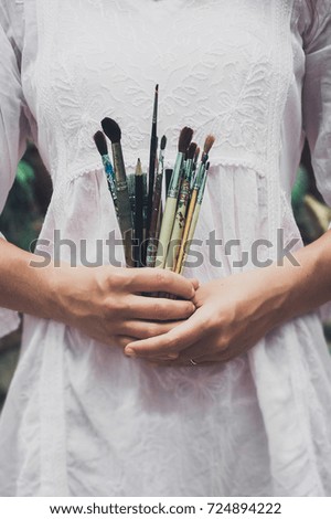 Artistic brushes in the hands of the artist's girl