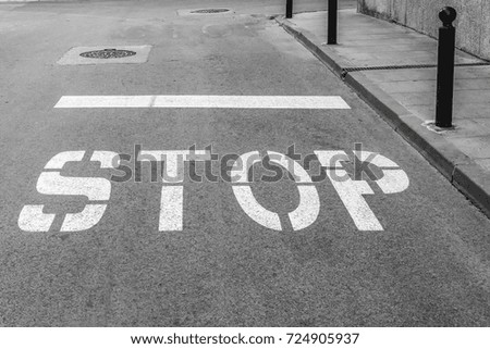 On the asphalt roadway marked the road marking "STOP"