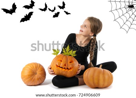 Pretty girl holding a pumpkin. Halloween. The girl smiles. Joy, emotion, holiday.