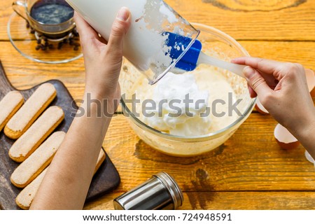 Photo of cooking tiramisu, human hands with culinary trowel