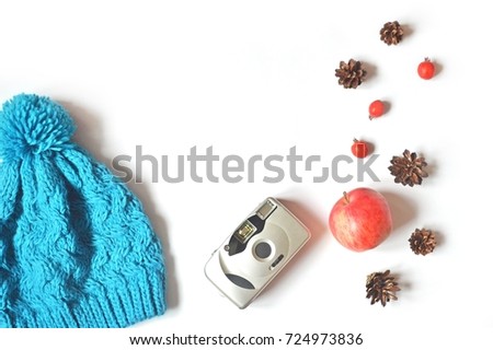 Blue hipster hat, vintage camera, red apple, berries and pine cone on a white background. Mockup, flat lay photo, top view