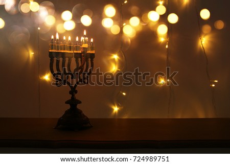 Low key image of jewish holiday Hanukkah background with menorah (traditional candelabra) and burning candles.