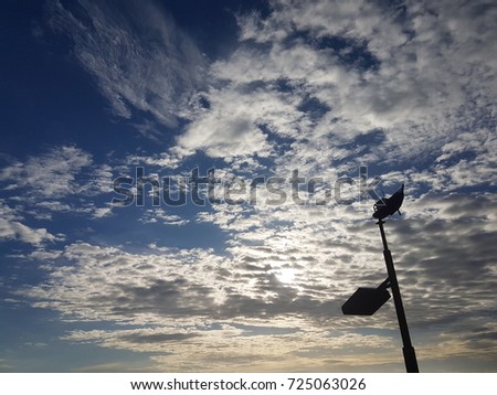 Silhouette of Street lamp with boat shape on beautiful blue golden sky, chill out concept