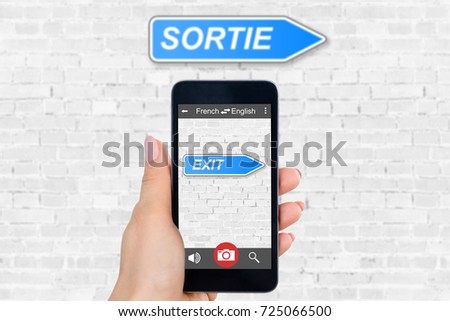 Person's Hand Holding Mobile Phone With Language Translator Application