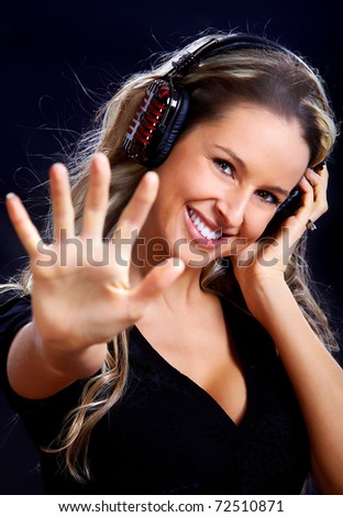 Happy young woman with headphones. Over dark   background