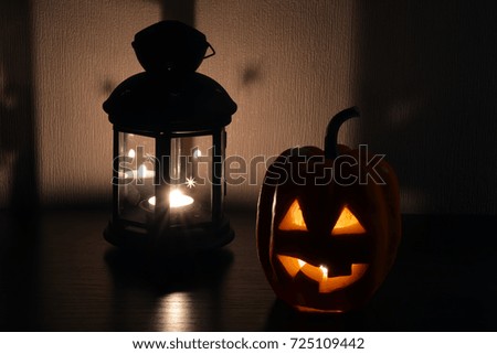 Pumpkin with cut eyes and mouth with a candle inside on a dark background - a symbol of Halloween