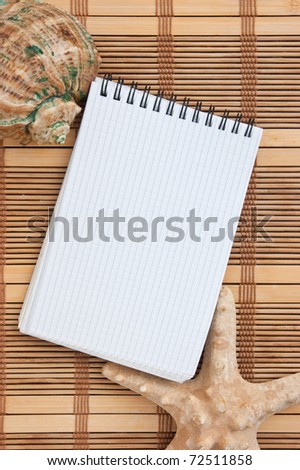 notebook on the background of mats and sea shells