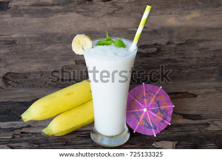 Banana smoothies on old wooden background.