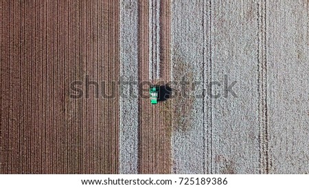 Aerial view of a Large green Cotton picker working in a field. Royalty-Free Stock Photo #725189386