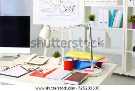 Office table with blank notepad and laptop