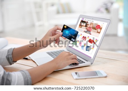 Woman using laptop and credit card for internet online shopping at table