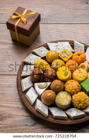 Stock photo of Indian sweets served in silver or wooden plate. variety of Peda, burfi, laddu in decorative plate, selective focus