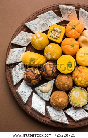 Stock photo of Indian sweets served in silver or wooden plate. variety of Peda, burfi, laddu in decorative plate, selective focus Royalty-Free Stock Photo #725228725