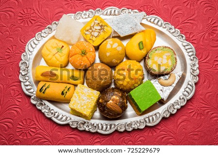 Stock photo of Indian sweets served in silver or wooden plate. variety of Peda, burfi, laddu in decorative plate, selective focus


