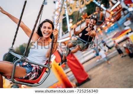 Two friends at amusement park. Soft focus, high ISO, grainy image. Royalty-Free Stock Photo #725256340