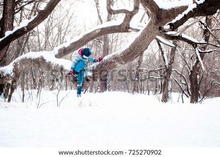 Little girl plays with the snow in a park