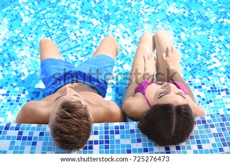 Happy young couple in swimming pool at resort