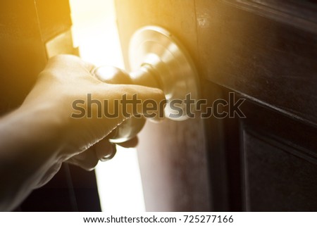 a man hand grab at door knob and opening the door to escape or to find the successful light 