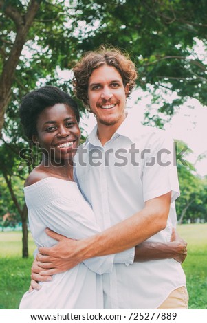 Portrait of happy young couple in white embracing
