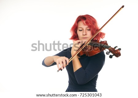 Beautiful young redhead woman playing the violin on white background with copy space