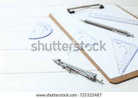 triangle, compass, ruler, protractor on white wooden desk