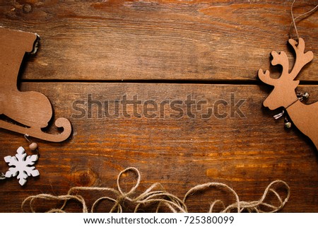 Christmas and New Year holiday background. Close up handmade ornaments of skate and deer on separate parts on wooden backdrop, festive decoration concept. Free space in the middle