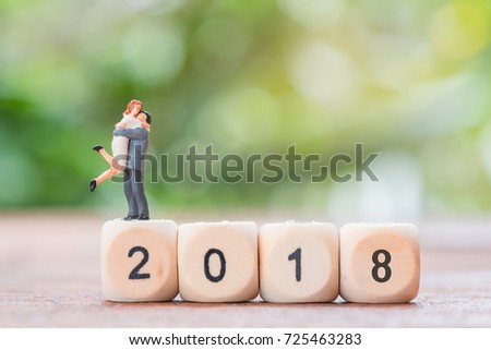 Miniature couple in love standing on wooden block number 2018 with green background,success and happy concept. Royalty-Free Stock Photo #725463283