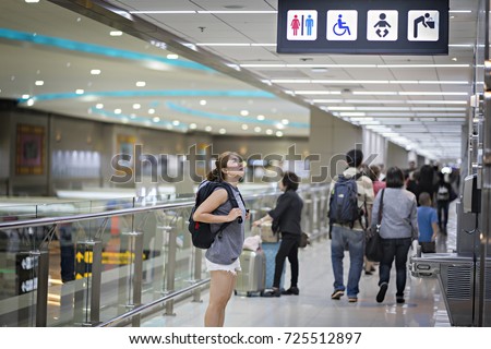 Passengers watch the  toilet sign in airport.Toilets icon. Public restroom signs with a disabled access symbol. Interior of airport terminal.