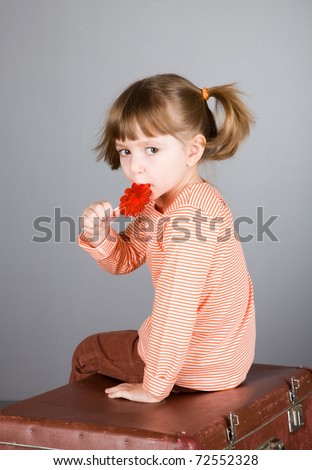 four-year girl with the big sugar candy on a gray background