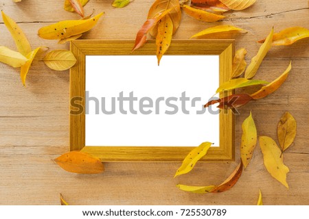 Blank Golden wooden photo frame on wooden board with autumn leaves, clipping path.