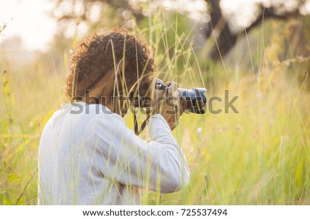 Blurred photo of Professional photographer are shooting in a meadow during sunset.
