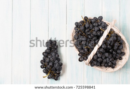 Black grapes on a light wooden background, horizontal, selective focus, harvest, autumn, top view 