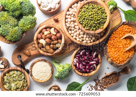 Vegan protein source. Beans, lentils, nuts, broccoli spinach and seeds. Top view on white table. Healthy vegetarian food. Royalty-Free Stock Photo #725609053