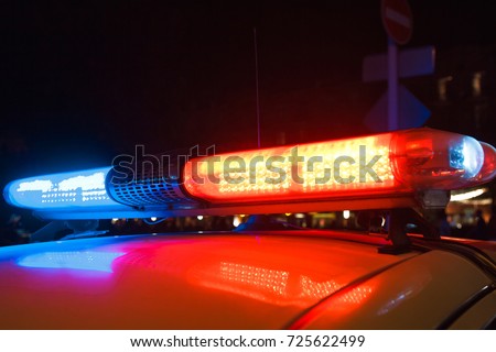 Red light flasher atop of a police car. Royalty-Free Stock Photo #725622499