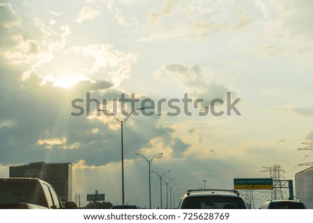 Car traffic on freeway at sunset with light rays in Houston, Texas, USA.