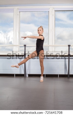 Ballet class, girl ballerina in a gymnastic swimsuit is jumping
