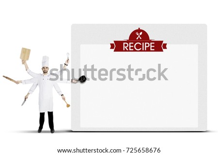 Picture of Arabian man chef is holding kitchen utensils with many hands while standing near a recipe board
