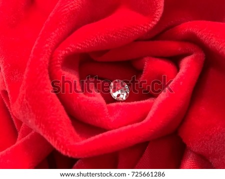 blurry picture of red velvet rose with diamond in middle 