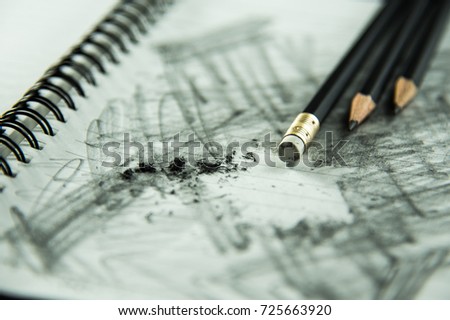 pencil eraser with eraser dust on notebook, remove pencil drawing from notebook in close up view, mistake and error concept