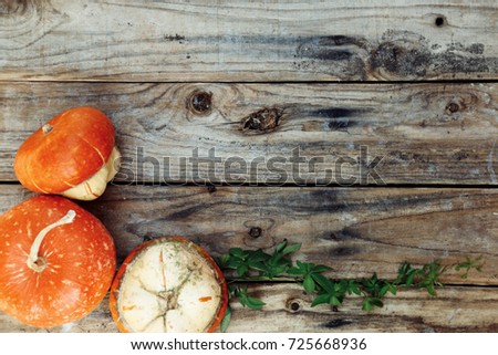 Autumnal background with pumpkins on old wooden table