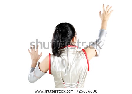 Back view of futuristic woman touching virtual screen while wearing silver latex clothes, isolated on white background