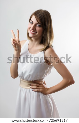 beautiful Ukrainian girl showing peace sign in white dress