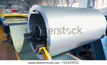 Rolled steel. Stack of rolls, Cold rolled steel coils in action. Galvanized Steel Sheet and rusty rim. Cold rolled steel coils. he drum turns the metal sheets in the production. Industrial