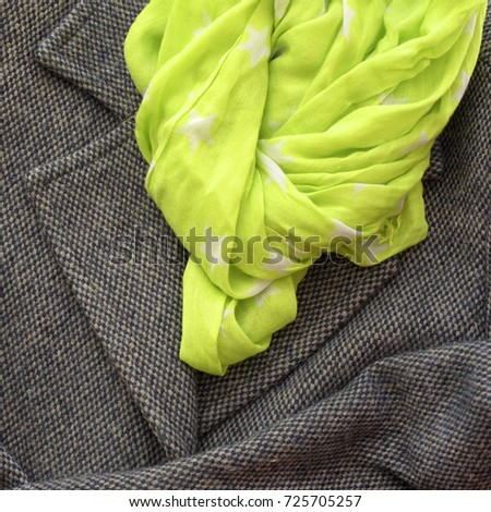 Women's coat gray color and scarf yellow. Textured background, the concept of fashion and design