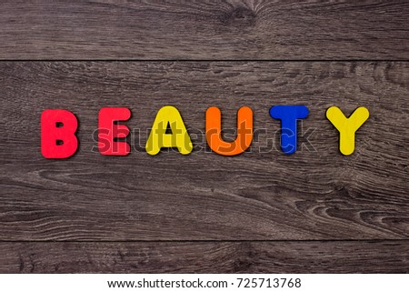 Word beauty from wooden letters on dark wooden background