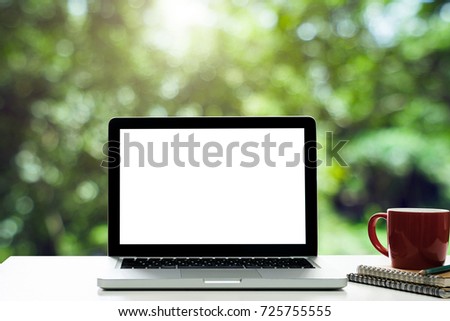 Conceptual workspace,Laptop with blank screen and notepad and coffee cup on desk white at blurred background at light bokeh.