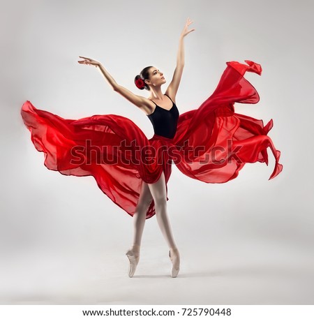 Ballerina. Young graceful woman ballet dancer, dressed in professional outfit, shoes and red weightless skirt is demonstrating dancing skill. Beauty of classic ballet. Royalty-Free Stock Photo #725790448